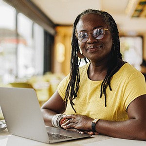 Woman smiling while working on laptop