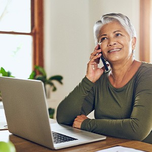 Woman smiling while talking on laptop