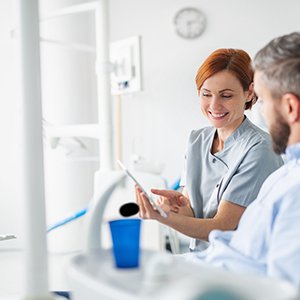Smiling dentist reviewing treatment plan with patient