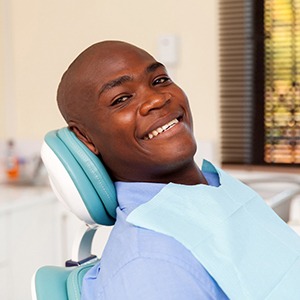 A man smiling in a dental chair.
